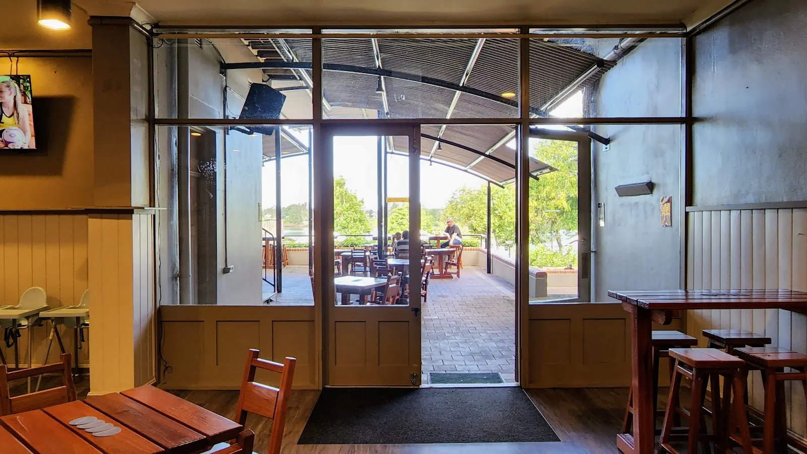 The front bar, looking out through open glass doors to tables on the deck