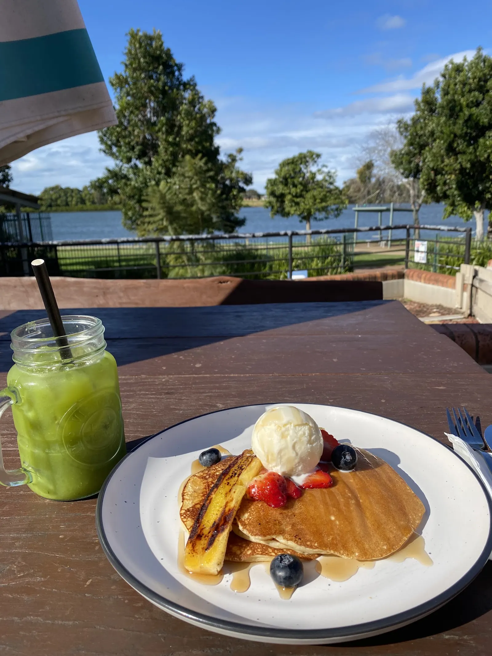 Pancakes with berries and ice cream on the deck, the river in the background
